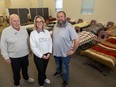 John Maddox, left, a warden of Old St. Paul's Anglican Church in Woodstock, Sheri Vindasius, executive director of Operation Sharing, and Time Dukes, shelter team lead, stand in an area of the church where 25 beds have been added to an existing emergency shelter. Photo shot on Tuesday, March 26, 2024. (Derek Ruttan/The London Free Press)