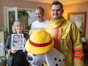 Liam Phillips, 22, often a friendly sight along Springbank Drive in his Sparky costume, is with his parents Kim and Richard Phillips on Wednesday, March 6, 2024. Because of his son's autism, Richard is helping Jamaican educators better understand the diagnosis.  (Mike Hensen/The London Free Press)