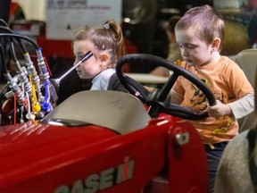 Hazel Park, 6, and her brother Paul, 3, check out a smaller tractor among the giant ones on display at the London Farm Show at the Western Fair Agriplex on Wednesday March 6, 2024. (Mike Hensen/The London Free Press)