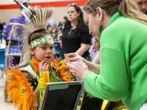 Jasper Jamieson, 9, purchases some jewelry from Terri King at an end-of-year celebration at Fanshawe College's institute of Indigenous learning on Thursday, March 21, 2024. (Mike Hensen/The London Free Press)