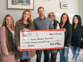 The team presents a cheque to the Huron Women's Shelter.