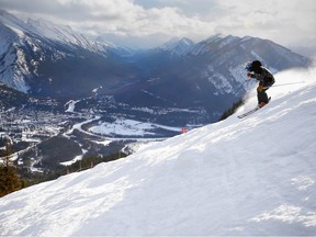 A skier at Mount Norquay off the Big Chair, with the townsite Banff in the background.