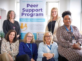 Cindy Hayward-Dale (back right), interim director of Organizational Health, Organizational Development, and Volunteer Engagement for Brantford Community Health System, and Audrey Zheke (front right), peer support and wellness specialist, sit with BCHS Peer Support Program team members.