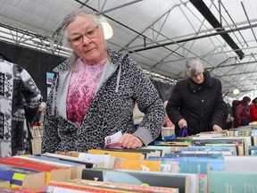 Linda Ross scans one of the tables at the Rotary Club of Sarnia Bluewaterland used book sale earlier this year at DeGroot's Nurseries on London Line in Sarnia.