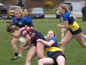 Assumption College’s Macie Good is dragged down by Brantford Collegiate Institute’s Katie Purcell during an AABHN girls rugby game on Wednesday at Delhi District Secondary School. Brian Smiley