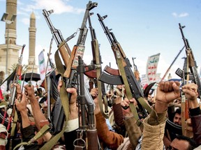 Demonstrators lift up assault rifles as they gather during an anti-Israel rally outside of al-Saleh mosque in Yemen's Houthi-held capital Sanaa on Friday, March 29, 2024, amid the ongoing conflict in the Gaza Strip between Israel and the militant group Hamas.