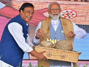 India's Prime Minister Narendra Modi, right, plays traditional drums as the chief minister of Assam state Himanta Biswa Sarma watches during an election campaign rally at Nalbari in Assam state on April 17, 2024, ahead of the country's upcoming general elections. (Photo by BIJU BORO/AFP via Getty Images)