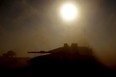Israel's southern border with the Gaza Strip shows an Israeli tank silhouetted against the sun as it rolls near the Palestinian territory on April 17, 2024, amid the ongoing conflict between Israel and the militant group Hamas.