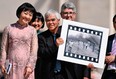 Vietnamese-US photographer Nick Ut holds his Pulitzer and World Press Photo Award, 1972 photograph Napalm Girl, depicting Kim Phuc, left, as they attend Pope Francis' weekly open-air general audience in St. Peters' square on May 11, 2022 at the Vatican. (Photo by ALBERTO PIZZOLI/AFP via Getty Images)