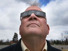 Steven Pellarin, a University of Windsor astronomy professor and vice-president of the Royal Astronomical Society of Canada, displays a pair of eclipse glasses on March 20, 2024. (Dan Janisse/Postmedia Network)