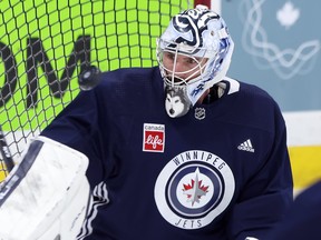 Connor Hellebuyck tracks a rebound that bounced off him during Winnipeg Jets practice on Monday.