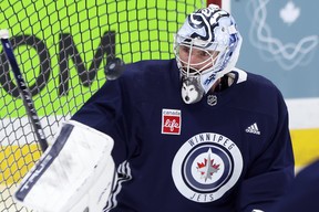 Connor Hellebuyck tracks a rebound that bounced off him during Winnipeg Jets practice on Monday.
