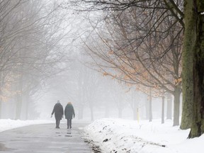 Early-morning walkers make their way through a fog-shrouded Springbank Park in London on Wednesday, Jan. 24, 2024. The dense cloud triggered by a warming spell cancelled rural school bus service in much of the area around London. (Derek Ruttan/The London Free Press)