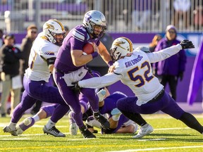 Western quarterback Jerome Rancourt runs for yards past Laurier's Ethan Gregorcic in the Yates Cup on Saturday, Nov. 11, 2023, in London. (Mike Hensen/The London Free Press)