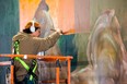 Moises Frank of Toronto works on his mural beneath the Florence Street entrance at Western Fair District in London on Wednesday, April 17, 2024. (Mike Hensen/The London Free Press)