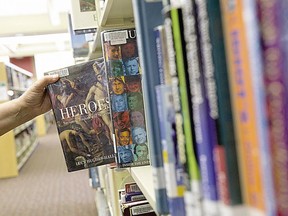 A book is pulled from the shelf at a London Public Library branch in this 2013 file photo.