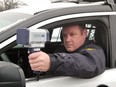 An officer uses a radar gun to catch speeders in this file photo.