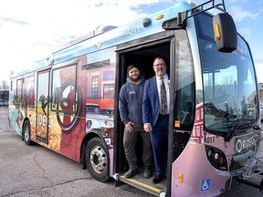 Dustyn Lachine, left, with Impact Graphics, the company that has wrapped a Chatham-Kent transit bus with a mural highlighting local history, is seen here with Mayor Darrin Canniff, during the unveiling on Monday. (Supplied photo)