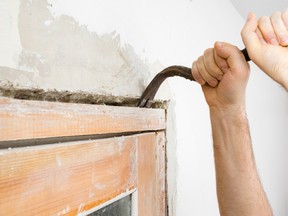 Stock photo of crowbar removing top of door frame
