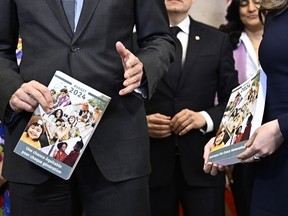 Prime Minister Justin Trudeau, left, and Deputy Prime Minister and Minister of Finance Chrystia Freeland hold copies of the federal budget as they pose for a photo before its tabling, on Parliament Hill in Ottawa, on Tuesday, April 16, 2024.