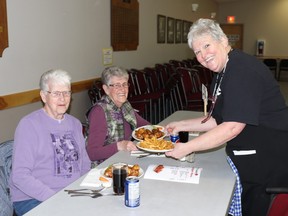 Ilene Blasko, left, and Bonnie Geinger received their food from Margaret Thibault at the annual volunteer appreciation event in the Mayerthorpe Legion on Thursday. Blasko and Geinger both volunteer with the Mayerthorpe cemetery association. The night was part of National Volunteer Week.