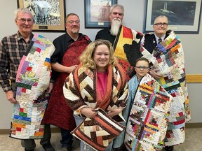 Veterans and one veteran's son were wrapped in their Quilts of Valour at the Mayerthorpe Legion. Receiving the quilts were (back, l-r) Ernie LaJeunesse, Matt Pettifer, Brian Stewart and James Wood, and (front) Brieana Isabelle and Henry Isabelle, son of Brieana and Steve Isabelle.