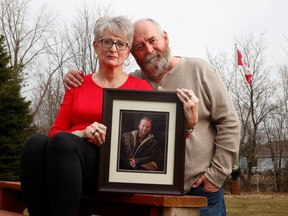 Yvonne McIsaac and her husband, Dave, hold a photo of their son, Russell, who died of colon cancer at the age of 38.