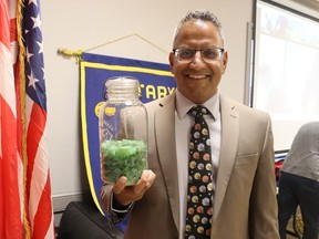 Deve Persad, executive director of The Greater Glass Co., a Sarnia-based social enterprise that sells jewelry made from beach glass to support the fight against human trafficking, shows off some their raw material before addressing the Rotary Club of Sarnia Tuesday.