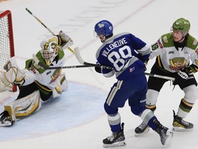 Nathan Villeneuve, middle, of the Sudbury Wolves, fires the puck past goalie Mike McIvor, of the North Bay Battalion, as Jacob LeBlanc, of the Battalion, attempts to tie up Villeneuve during OHL playoff action at the Sudbury Community Arena in Sudbury, Ont. on Tuesday April 16, 2024.