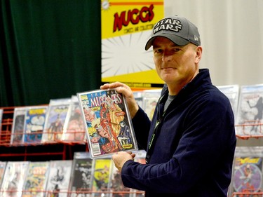 Paul Virc, of Timmins, holds up one of the many comics he had for sale during the opening day of the 2024 Northern Ontario Expo at the McIntyre Arena on Saturday. When it comes to DC or Marvel, Virc says Timmins is evenly split on the two publishers, depending on which one most recently had a movie hit the big screen. THOMAS PERRY/THE DAILY PRESS