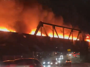 A flaming train moves across a London rail overpass in this screengrab from a video posted to Twitter on April 21, 2024.