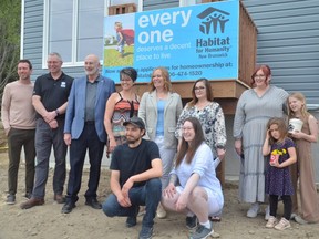 Local dignitaries and Habitat for Humanity representatives gathered Wednesday at Miramichi's first Habitat duplex to dedicate the home to the families chosen for each unit. Kneeling in front are residents Kevin Linnard, left, and Shannon Linnard. Back row, from left: Miramichi Mayor Adam Lordon, Habitat New Brunswick CEO Perry Kendall, Miramichi Bay-Neguac MLA Réjean Savoie, Miramichi MLA Michelle Conroy, Housing Minister Jill Green, Habitat selection committee chair Peggy McLean, and resident Sabrina Mills and her daughters Reese and Claire.