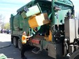 Joey Machado, a city sanitation operator, uses a side-loading truck to empty the first two bins of a multi-residential green bin pilot program at 9 Commissioners Rd. E. in London on Friday, April 26, 2024. (Jack Moulton/The London Free Press)