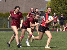Paris District High School’s Hailey Holgate takes a peek back as Pauline Johnson Collegiate defenders chase her down during an AABHN girls rugby game on Wednesday at Simcoe’s Holy Trinity Catholic High School. Brian Smiley