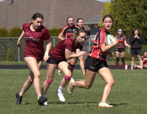 Paris District High School’s Hailey Holgate takes a peek back as Pauline Johnson Collegiate defenders chase her down during an AABHN girls rugby game on Wednesday at Simcoe’s Holy Trinity Catholic High School. Brian Smiley