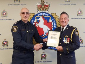 Chatham-Kent police Insp. Matt Stezycki, left, presents the 30-year fitness pin to Chief Gary Conn at Wednesday's police services board meeting. (Trevor Terfloth/The Daily News)