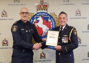 Chatham-Kent police Insp. Matt Stezycki, left, presents the 30-year fitness pin to Chief Gary Conn at Wednesday's police services board meeting. (Trevor Terfloth/The Daily News)