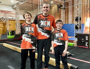 Coach Patrick Drolet poses for a photo between Ninja competitors Jonathan Kelly, left, and Luka Montpellier.