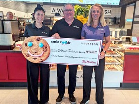 Tim Hortons franchisees Jessica Pritchard and Paul Grail flank foundation chief Mike Genge after this year's local Tim Hortons Smile Cookie campaign raised $55,000 for the Children’s Treatment Centre Foundation of Chatham-Kent recently. (Supplied)