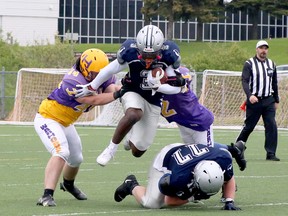 Sudbury Junior Spartans running back Zidain Allen leaps into the air in an attempt to evade a pair of Huronia Stallions tacklers during Ontario Summer Football League U18 action at James Jerome Sports Complex in Sudbury, Ontario on Saturday, May 25, 2024