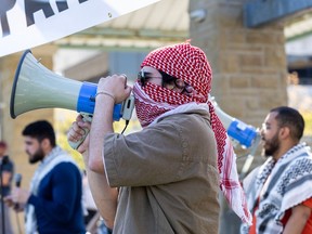 Men with megaphone leads pro-Palestinian protesters in chants as they occupy the lawn outside the University Community Centre at Western University in London, Ontario on Wednesday May 1, 2024. (Derek Ruttan/The London Free Press)