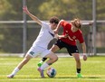 Gianluca DeCandido of the Mother Teresa Spartans, left, and Noah Bakke of the St. Thomas Aquinas Flames fight for the ball in a TVRA boys soccer game at Tricar Fields in London on Tuesday, April 30, 2024. The Spartans won 3-0. (Mike Hensen/London Free Press)