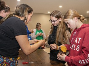 Ojibwe language teacher Nikki Shawana helps Lakewood Elementary School (Port Dover) students Kennedy Beck and Addie Simmons (right) make medicine pouches on Friday.