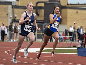 Eowynn Fowler (left) of Delhi District Secondary School and Phlly Van Nooten of the BCI Mustangs round the first turn in the senior women's 400 metre dash.