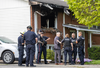 London police officers and firefighters talk in the driveway of a home at 1600 Nairn Ave. in northeast London following a fire that killed one person and sent a second to hospital on Tuesday, May 14, 2024. (Derek Ruttan/ The London Free Press)