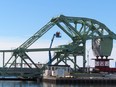 Workers use a lift to reach an upper portion of the Bascule bridge on the LaSalle Causeway