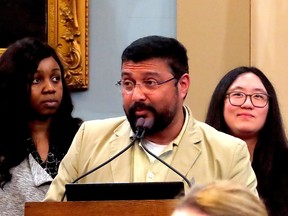 Siju Simon, president of the Kingston Malayali Association, speaks to Kingston city council with Annette Oguine, founder of the African Student Association, left, and Yu Jier Kou, coordinator of Kingston Immigration Partnership
