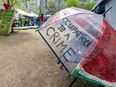 A hand-colored umbrella hangs on a chair outside the pro-Palestinian encampment on the campus of McGill University in Montreal Monday May 13, 2024