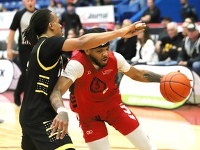 Ja'Myrin Jackson, right, of the Sudbury Five, dribbles past Nick Garth, of the London Lightning, during playoff action at the Sudbury Community Arena in Sudbury, Ont. on Monday May 6, 2024.