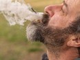 A man exhales marijuana smoke